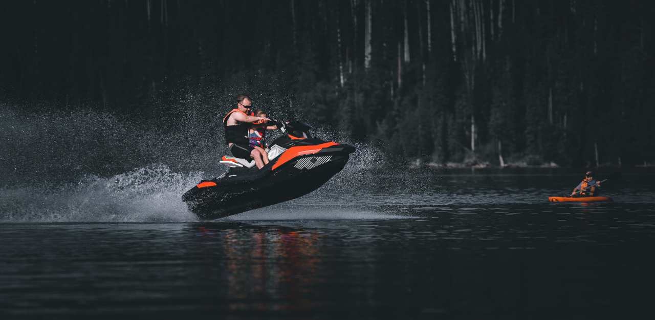 man riding a jet ski across river