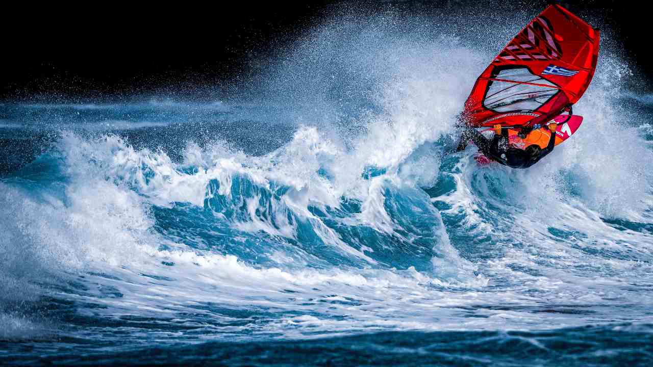 man windsurfing on waves